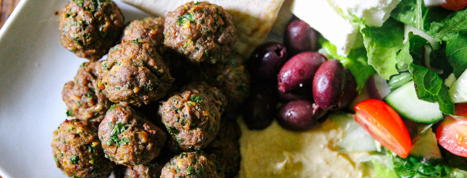 Lamb meatball platter with pita, salad, olives, and hummus