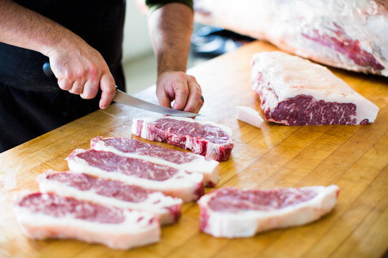 Butcher cutting New York Strips